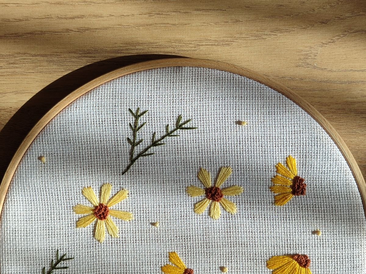 Hand-digitized floral machine embroidery design stitched in a wooden hoop